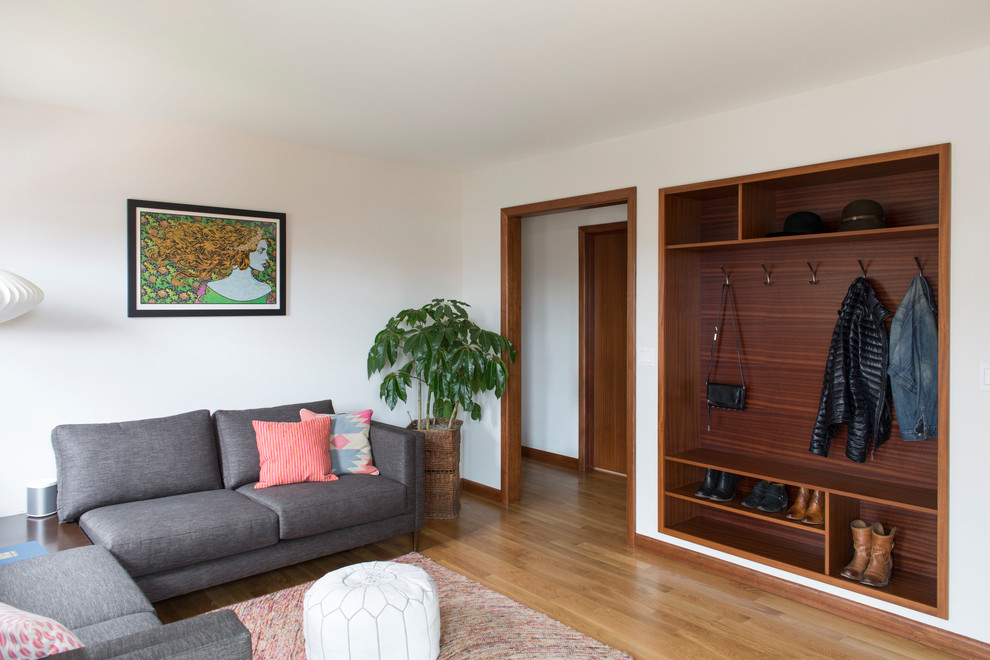 Modelo de sala de estar cerrada retro pequeña con paredes blancas, suelo de madera en tonos medios y alfombra
