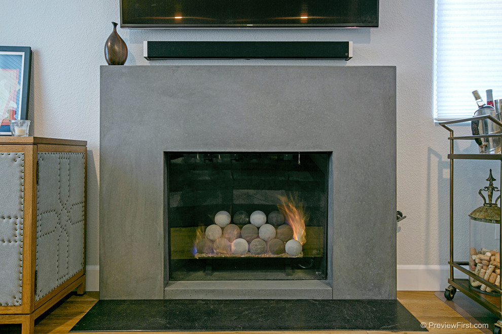 Inspiration for a medium sized industrial open plan games room in San Diego with medium hardwood flooring, a standard fireplace and a wall mounted tv.