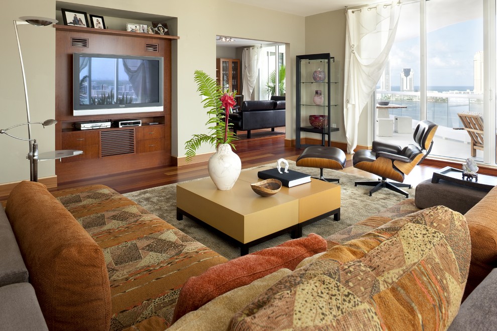 Aménagement d'une salle de séjour contemporaine avec un mur beige, un sol en bois brun et un téléviseur fixé au mur.