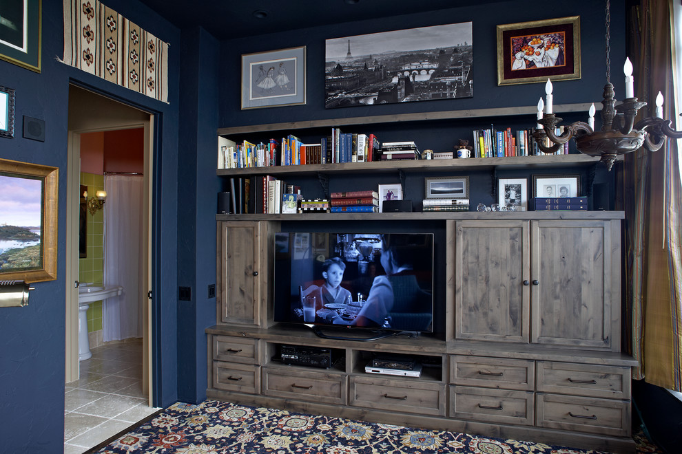 Cette photo montre une salle de séjour éclectique fermée et de taille moyenne avec une bibliothèque ou un coin lecture, un mur bleu, moquette et un téléviseur dissimulé.