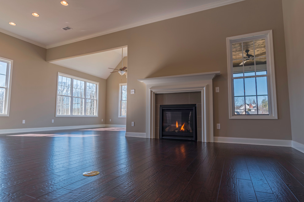 Family room - mid-sized transitional open concept dark wood floor family room idea in Other with beige walls, a standard fireplace and a tile fireplace
