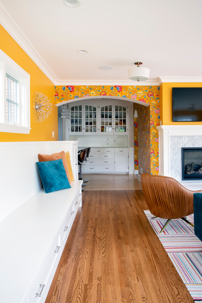 На фото: большая открытая гостиная комната в стиле фьюжн с желтыми стенами, паркетным полом среднего тона, стандартным камином, фасадом камина из плитки и телевизором на стене