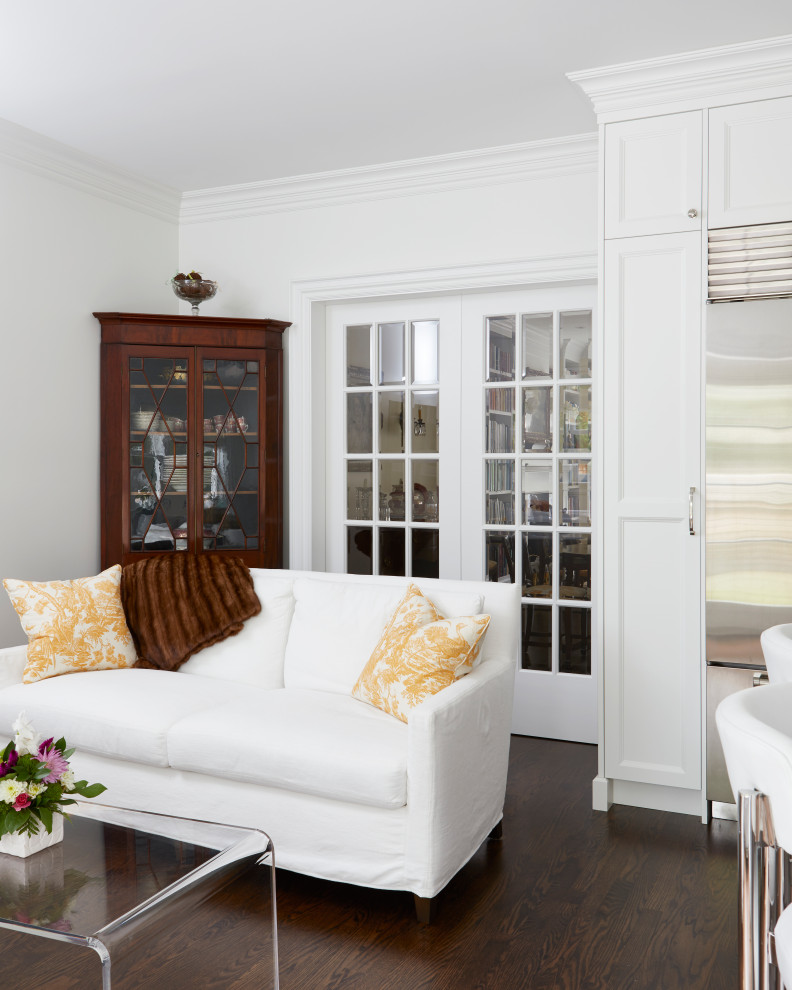 Modelo de sala de estar con rincón musical abierta tradicional pequeña con paredes blancas, suelo de madera oscura, televisor colgado en la pared y suelo marrón
