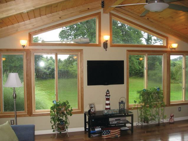 Imagen de sala de juegos en casa abierta tradicional grande sin chimenea con paredes beige, suelo de madera oscura y televisor colgado en la pared