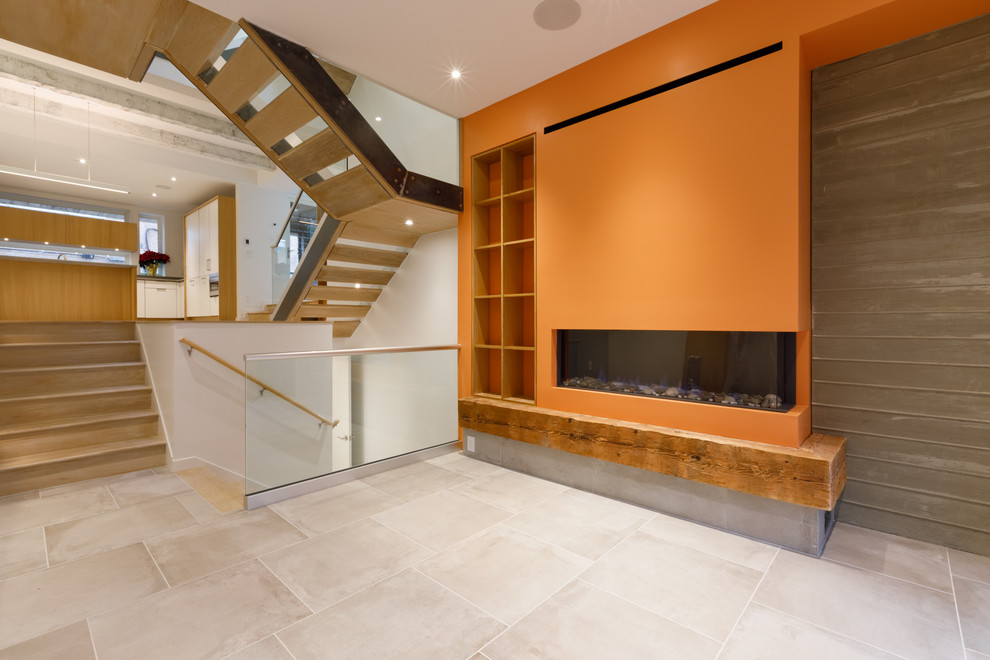 Offenes Modernes Wohnzimmer mit hellem Holzboden, Kamin und Kaminumrandung aus Beton in Philadelphia