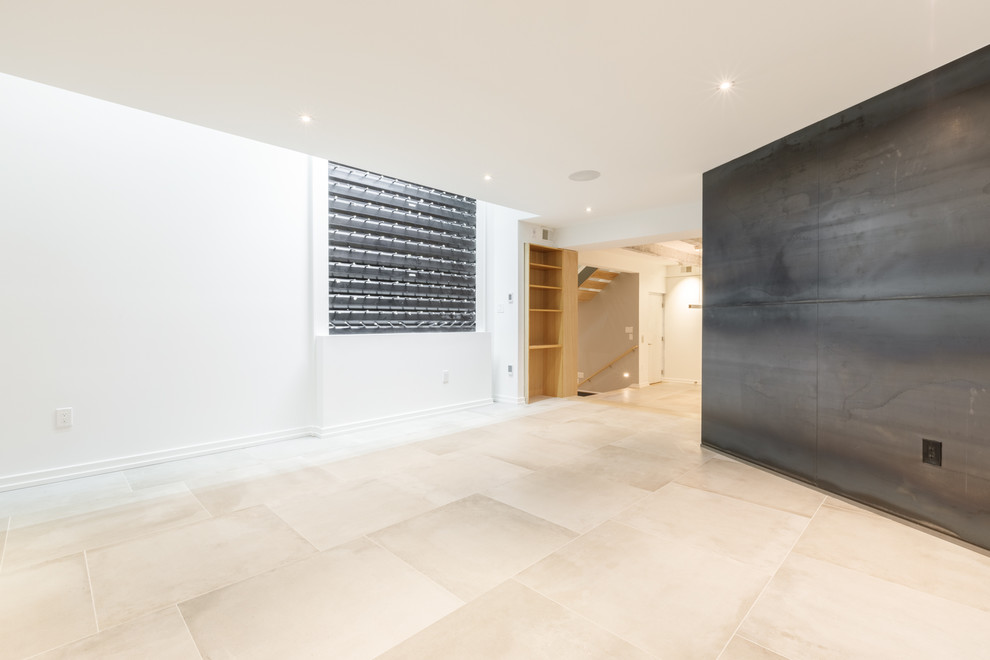 Imagen de sala de estar cerrada actual con paredes grises, suelo de madera clara, todas las chimeneas y televisor colgado en la pared