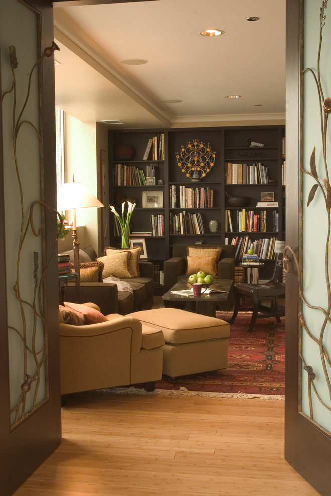 Foto di un soggiorno minimal con libreria, pareti beige e pavimento in bambù