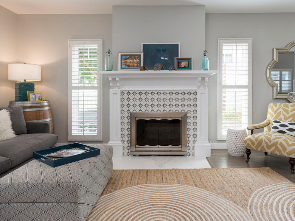Ejemplo de sala de estar abierta costera pequeña con paredes grises, marco de chimenea de baldosas y/o azulejos y panelado