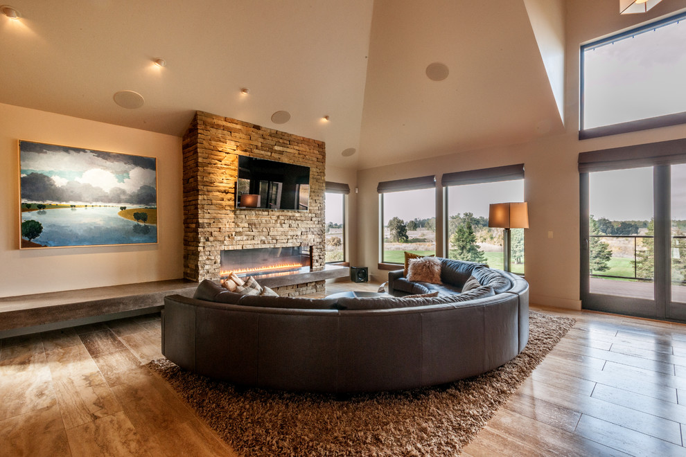 Contemporary open plan games room in Sacramento with travertine flooring, a ribbon fireplace, a stone fireplace surround and a wall mounted tv.