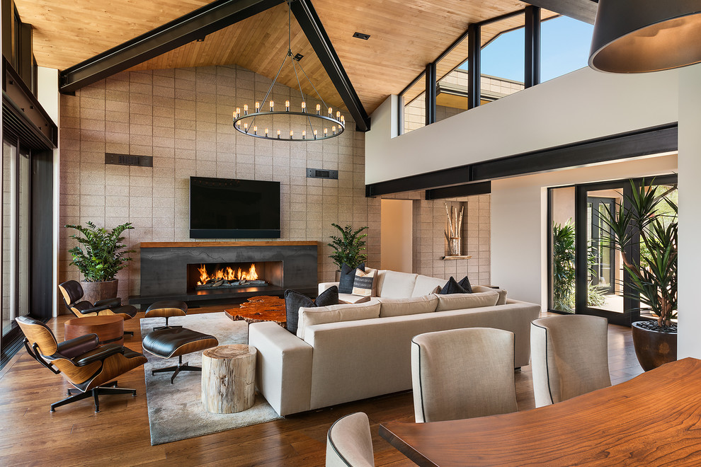 Offenes Modernes Wohnzimmer mit weißer Wandfarbe, braunem Holzboden und Gaskamin in Phoenix