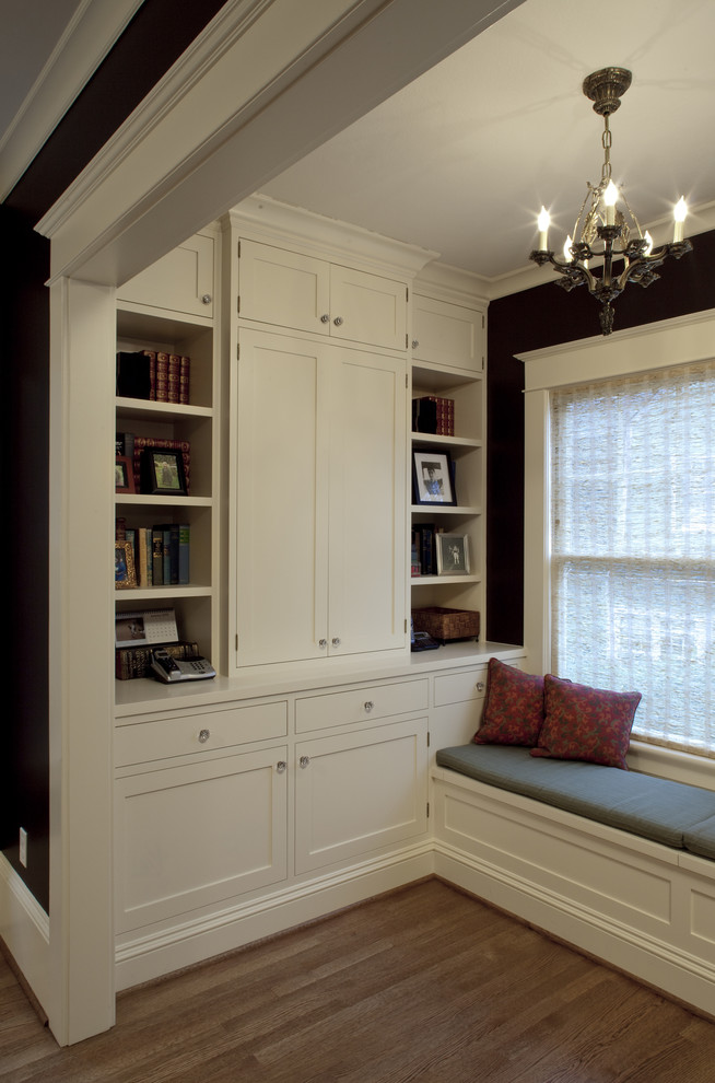 Immagine di un piccolo soggiorno stile americano chiuso con libreria, pareti nere, parquet chiaro, nessun camino e nessuna TV