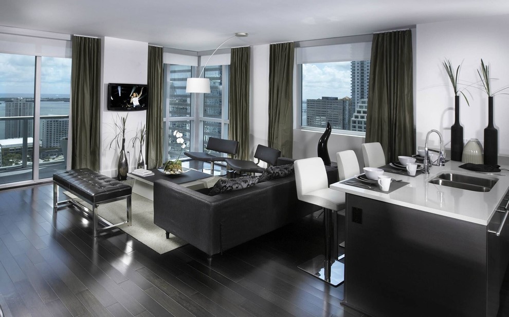 Diseño de sala de estar abierta contemporánea pequeña con paredes grises, suelo de madera oscura y televisor colgado en la pared
