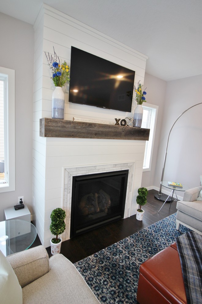 На фото: открытая гостиная комната среднего размера в современном стиле с серыми стенами, темным паркетным полом, стандартным камином, фасадом камина из плитки и телевизором на стене с