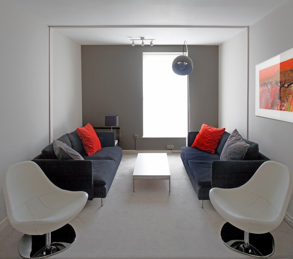 Cette image montre une salle de séjour design avec un mur gris et canapé noir.