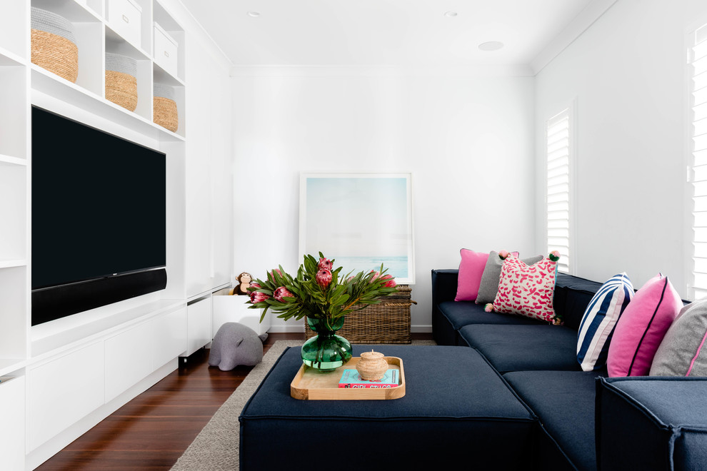 Ejemplo de sala de estar marinera sin chimenea con paredes blancas, suelo de madera en tonos medios y pared multimedia