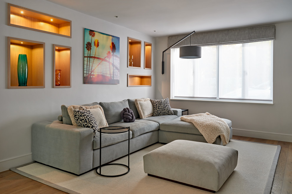 На фото: изолированная гостиная комната среднего размера в современном стиле с телевизором на стене