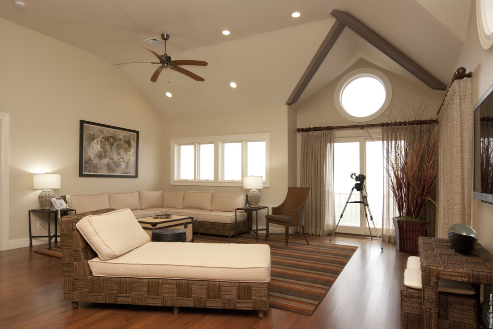 Cette image montre une salle de séjour design avec un mur beige, un sol en bois brun et un téléviseur fixé au mur.