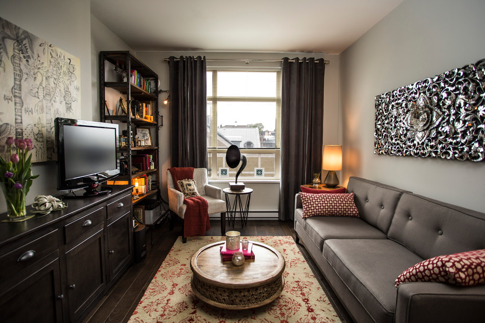 Foto di un soggiorno contemporaneo chiuso con pareti grigie, parquet scuro, TV autoportante e tappeto
