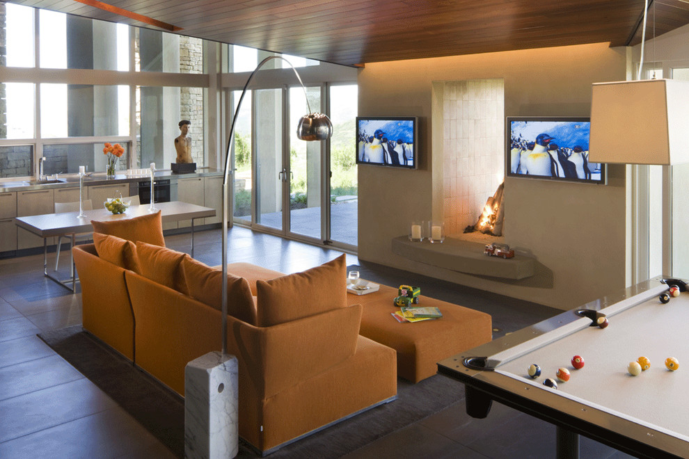 На фото: открытая гостиная комната в современном стиле с бежевыми стенами, двусторонним камином и телевизором на стене с