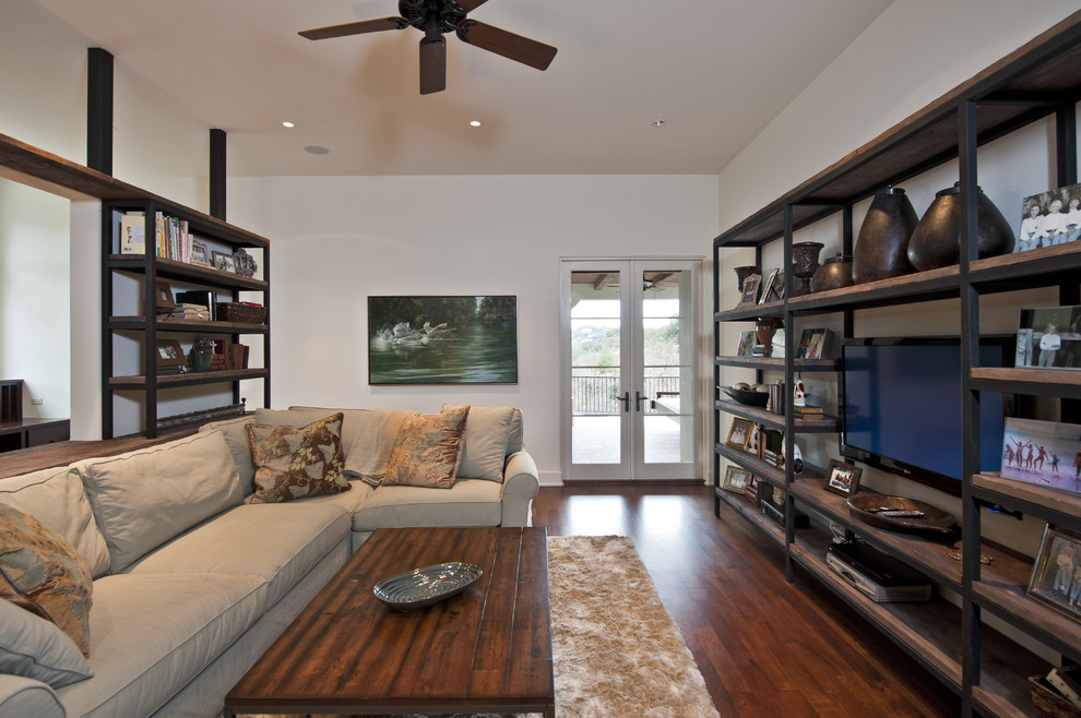Family room - contemporary dark wood floor family room idea in Austin with white walls and a wall-mounted tv