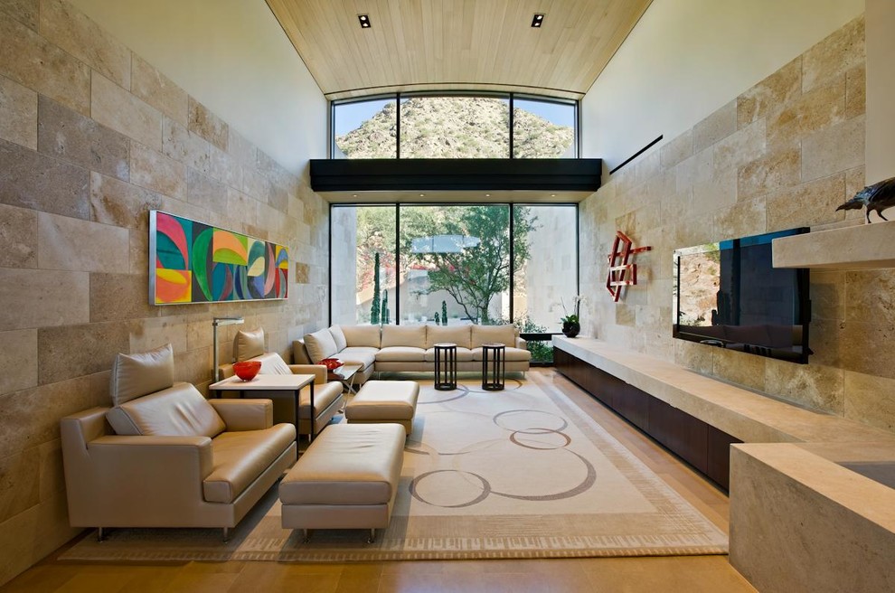 Imagen de sala de estar abierta actual con paredes beige, televisor colgado en la pared y alfombra