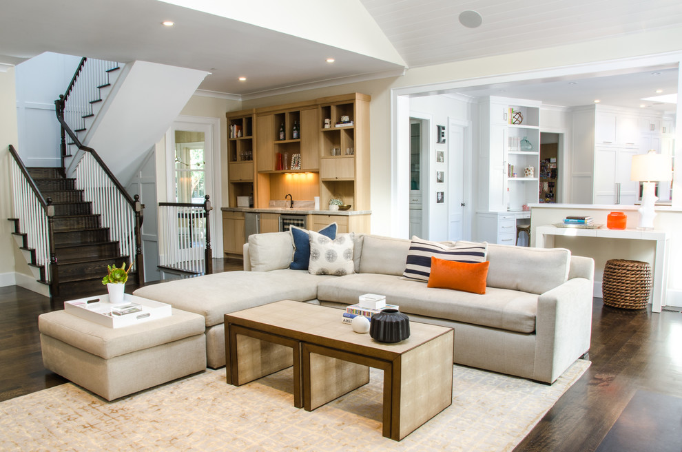 Diseño de sala de estar abierta actual con paredes beige y suelo de madera oscura