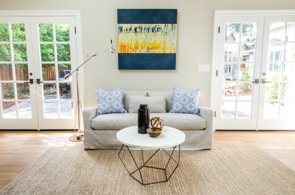 Immagine di un soggiorno design con pareti beige e parquet chiaro