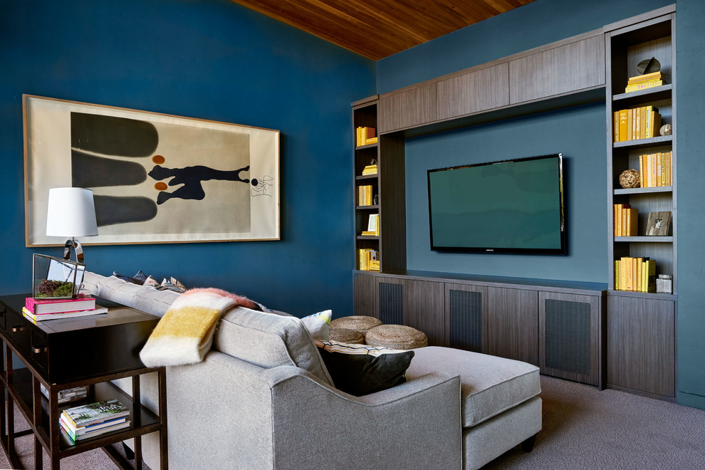 Idee per un soggiorno contemporaneo con libreria, pareti blu, moquette e TV a parete