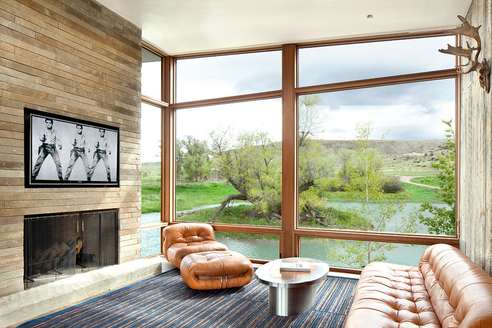 Стильный дизайн: открытая гостиная комната в современном стиле с стандартным камином и фасадом камина из камня - последний тренд