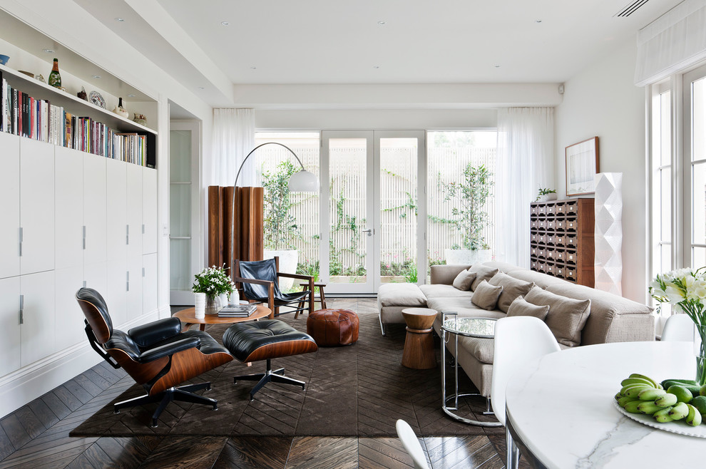 Modelo de sala de estar abierta contemporánea grande con paredes blancas y suelo de madera oscura