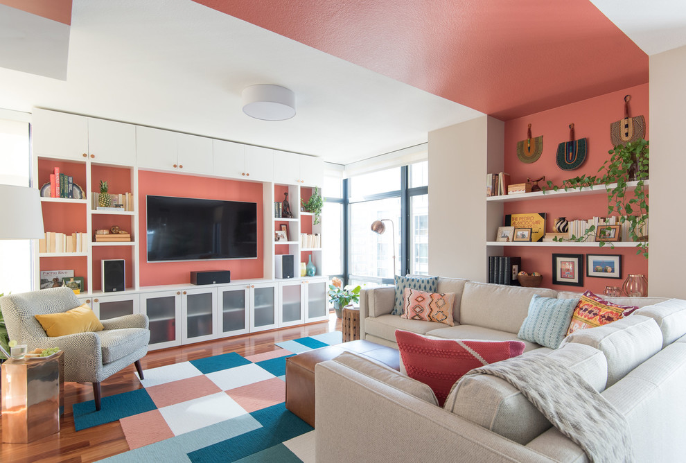 Aménagement d'une salle de séjour contemporaine avec un mur rose, un sol en bois brun, aucune cheminée et un téléviseur fixé au mur.