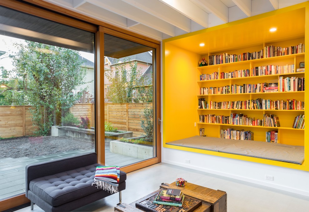 This is an example of a contemporary open plan games room in Portland with a reading nook, white walls, concrete flooring and grey floors.