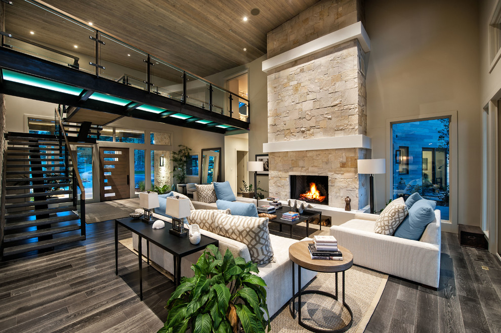 Photo of a large contemporary open plan games room in Salt Lake City with beige walls, dark hardwood flooring, a standard fireplace, a stone fireplace surround, no tv and grey floors.