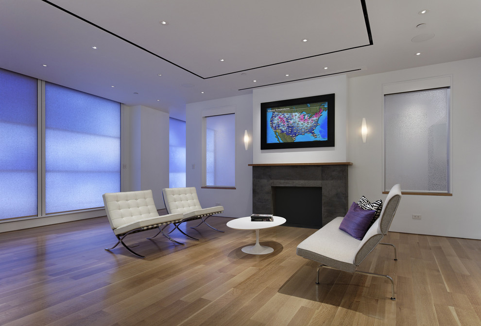 Foto på ett funkis allrum, med vita väggar, mellanmörkt trägolv, en standard öppen spis och en dold TV