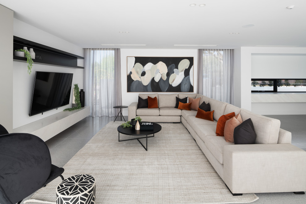 Diseño de sala de estar actual con paredes blancas, televisor colgado en la pared y suelo gris