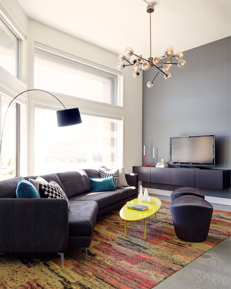 Offenes Modernes Wohnzimmer ohne Kamin mit grauer Wandfarbe, Betonboden und freistehendem TV in Seattle