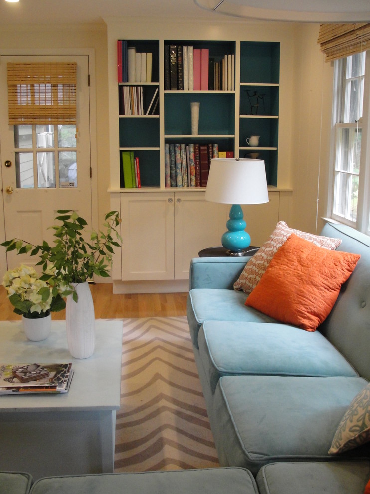 Imagen de sala de estar contemporánea de tamaño medio con paredes blancas, suelo de madera clara y televisor colgado en la pared