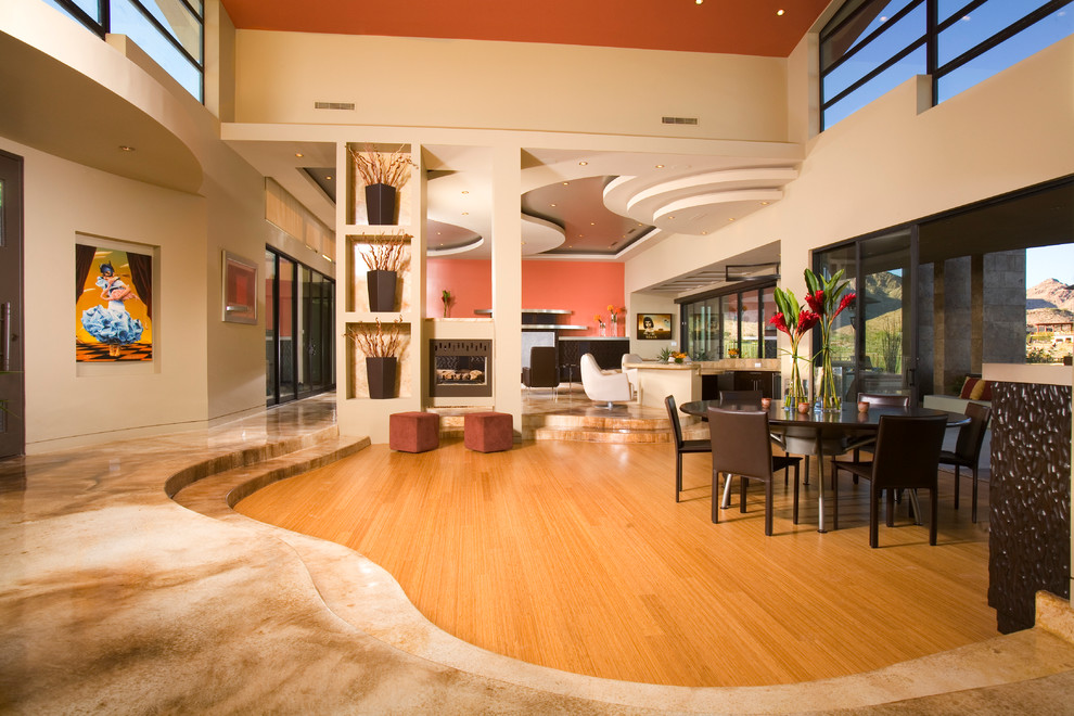 Diseño de sala de estar abierta contemporánea con paredes beige y suelo de madera en tonos medios