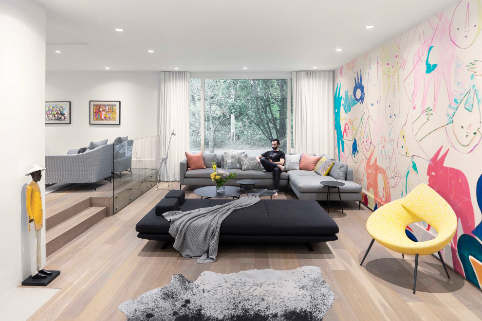 Design ideas for a contemporary open plan games room in Toronto with multi-coloured walls, light hardwood flooring, beige floors and a feature wall.
