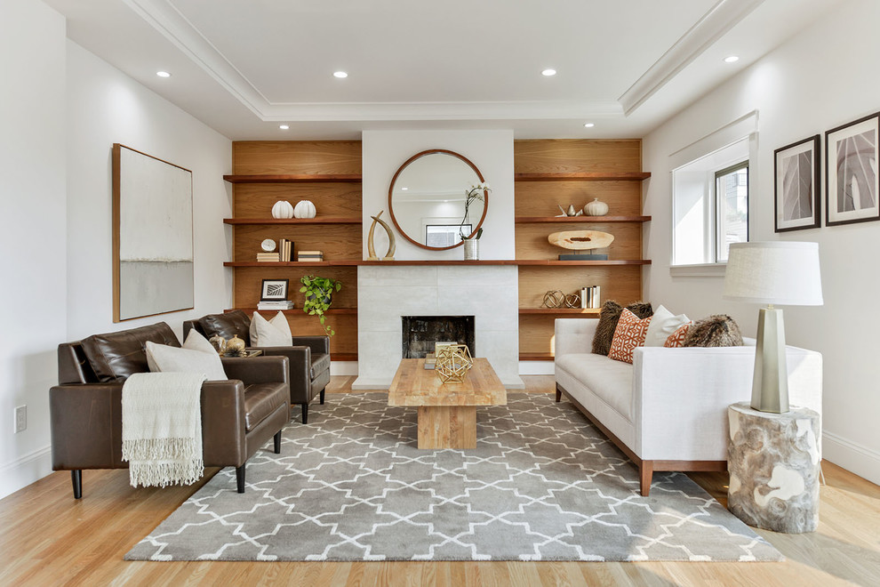 Immagine di un soggiorno contemporaneo con pareti bianche, parquet chiaro, camino classico e pavimento beige