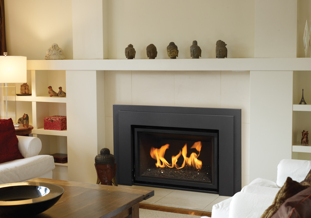 バンクーバーにある中くらいなコンテンポラリースタイルのおしゃれなファミリールーム (白い壁、標準型暖炉、漆喰の暖炉まわり、テレビなし) の写真