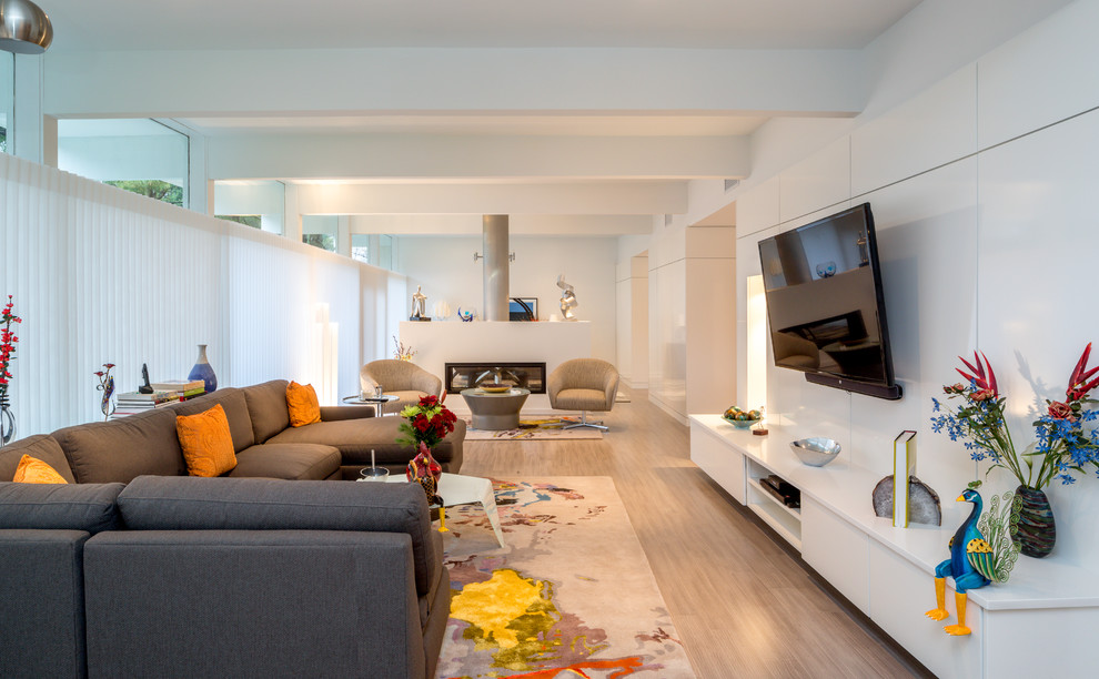 Diseño de sala de estar contemporánea con paredes blancas y televisor colgado en la pared