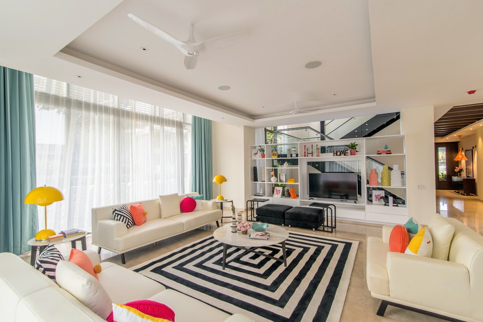 Источник вдохновения для домашнего уюта: открытая гостиная комната в современном стиле с белыми стенами, отдельно стоящим телевизором и бежевым полом