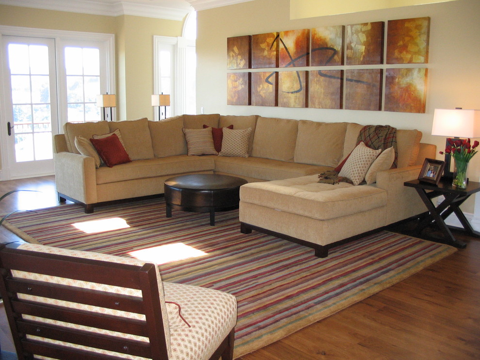 Diseño de sala de estar abierta contemporánea grande con paredes amarillas y suelo de madera en tonos medios