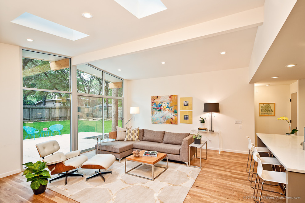 Foto de sala de estar abierta contemporánea con paredes beige y suelo de madera en tonos medios