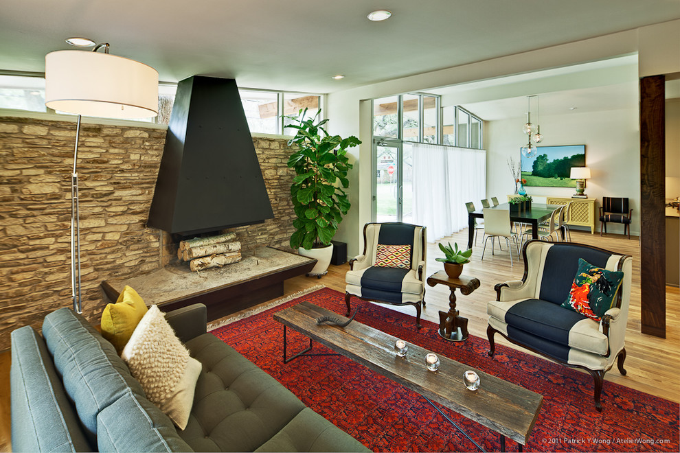 Diseño de sala de estar abierta actual con paredes beige, chimeneas suspendidas y marco de chimenea de piedra