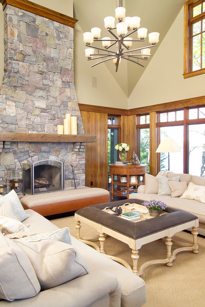 Exemple d'une salle de séjour tendance avec un mur beige, une cheminée standard et un manteau de cheminée en pierre.