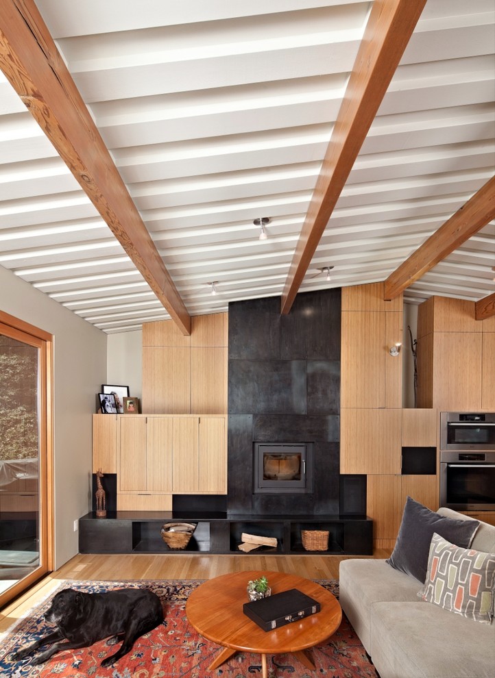 Diseño de sala de estar abierta contemporánea con paredes beige, suelo de madera en tonos medios y todas las chimeneas