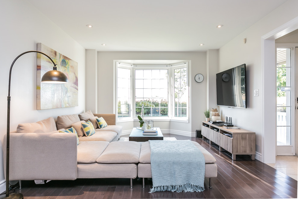 Esempio di un piccolo soggiorno design con TV a parete, pavimento marrone, pareti beige e parquet scuro