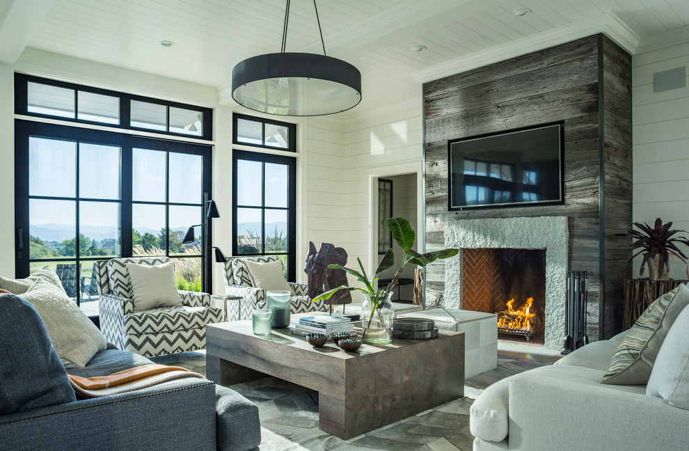 Inspiration for a cottage enclosed family room remodel in Burlington with white walls, a standard fireplace, a stone fireplace and a wall-mounted tv